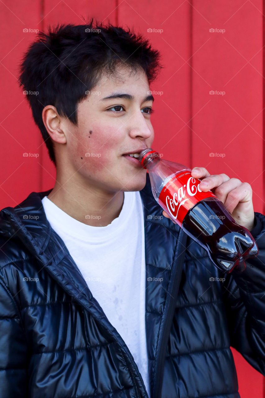 Young handsome man with a bottle of Coca-Cola