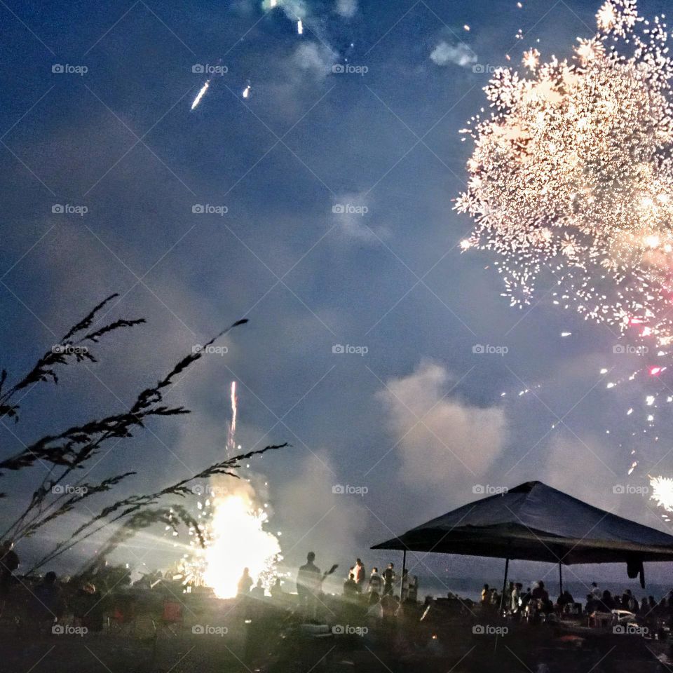 An array of fireworks being shot on a HOA private beach, celebrating the 4th of July.