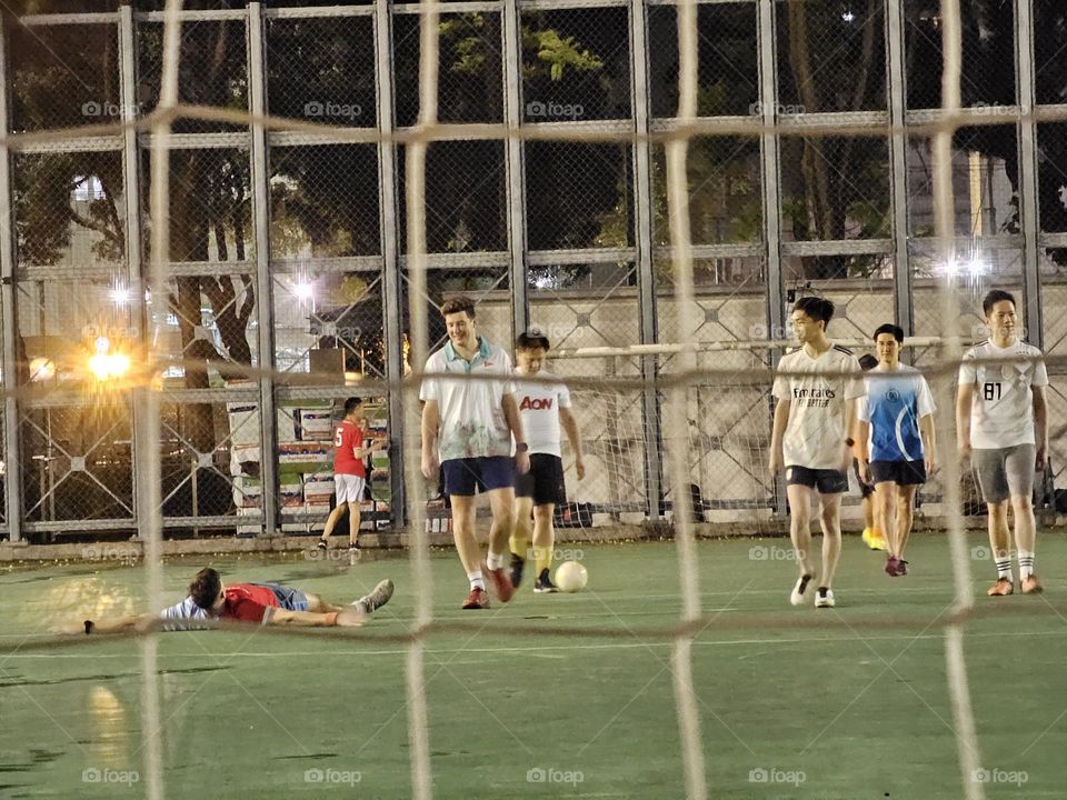 Men playing soccer after the rain at Hong Kong Victoria Park