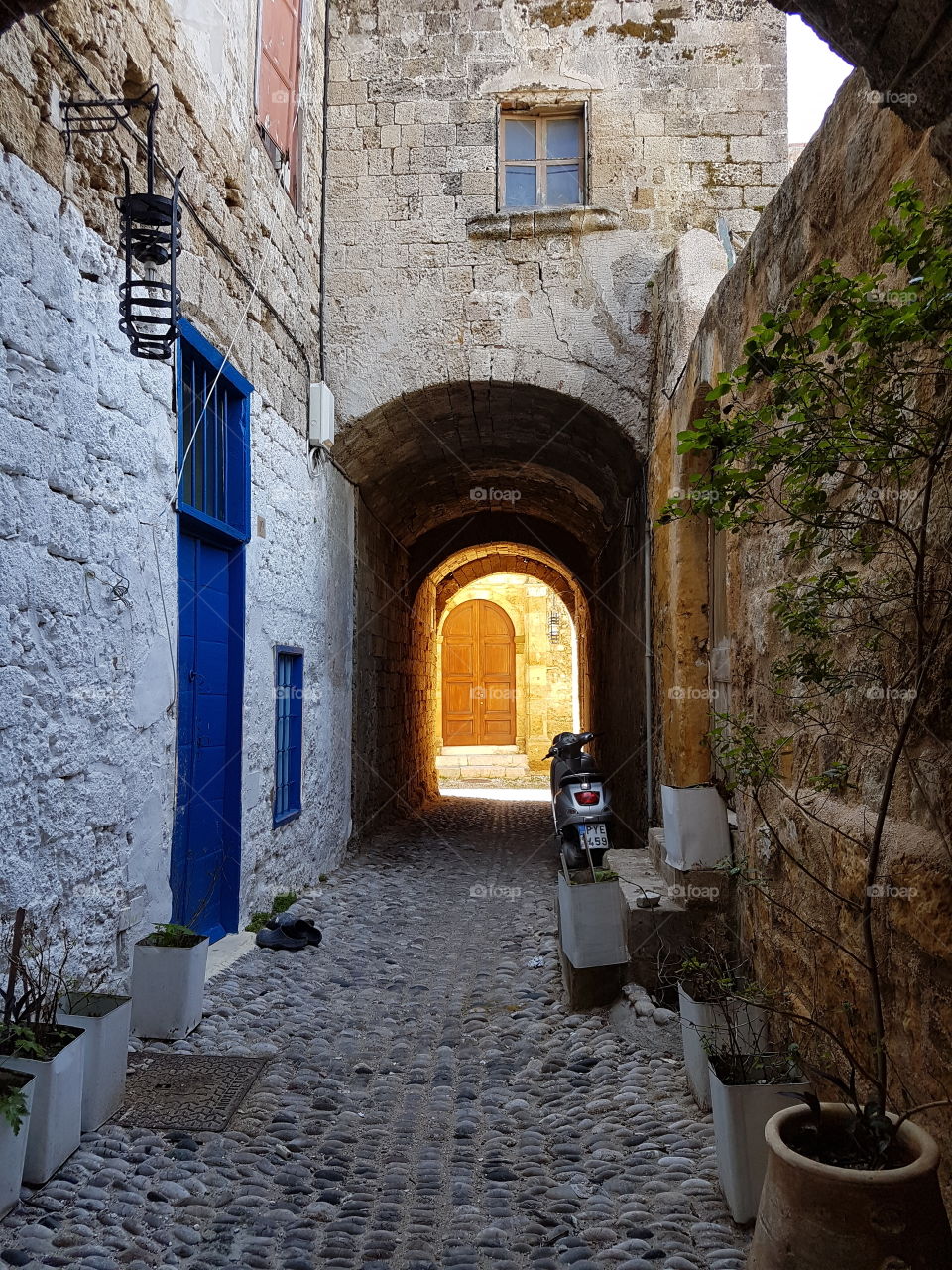 A typical street in Rhodes with an arch in background, Rhodes, Greece.