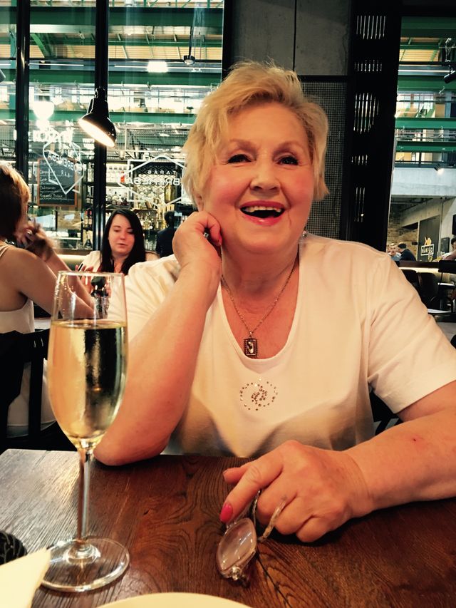 Smiling mature woman sitting with wine glass in restaurant