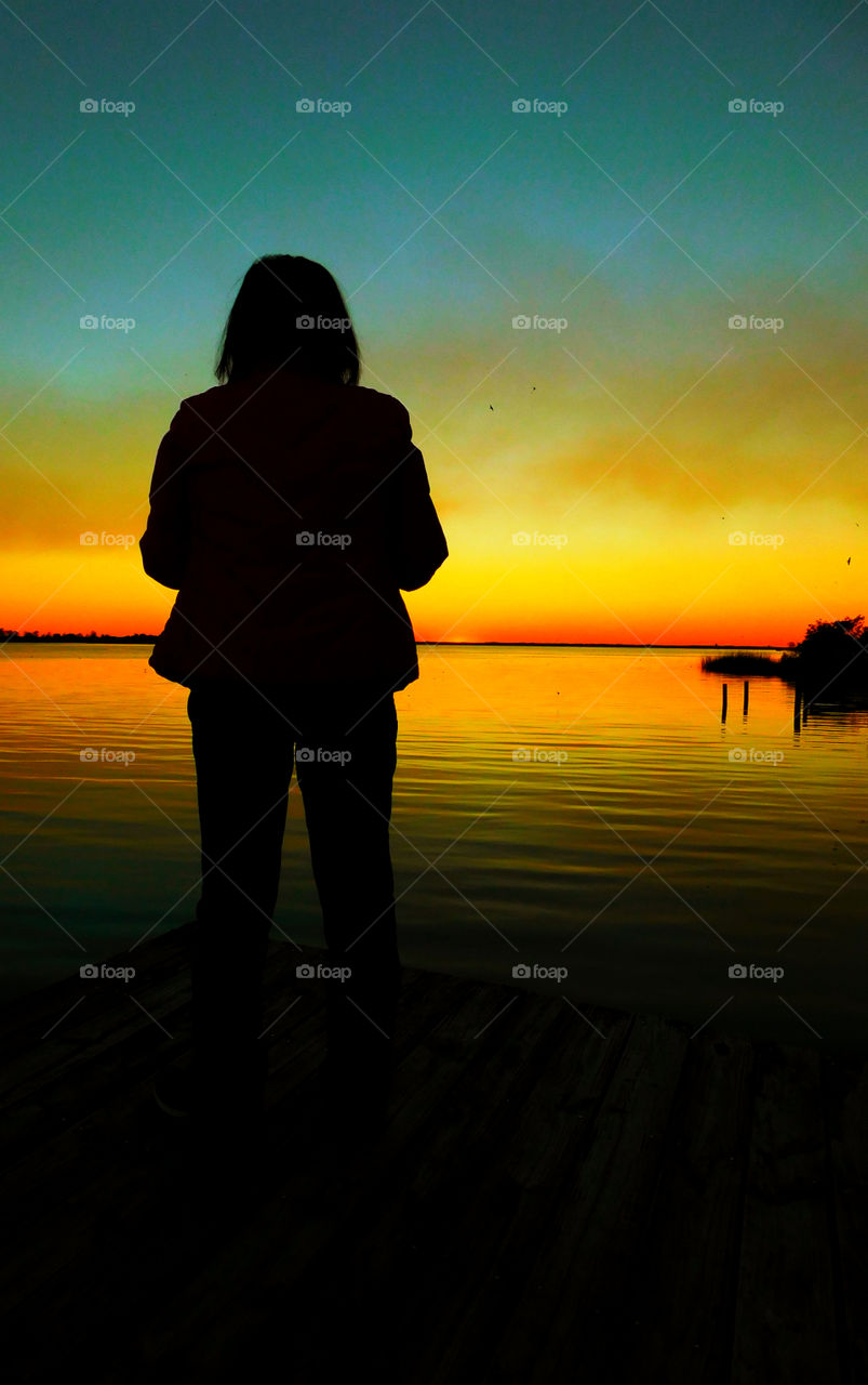 Mesmerizing Sunset!
A women is in awe as she observes a brilliant sunset over the bay!