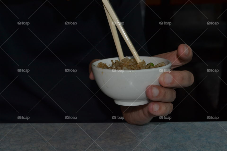 Man eating with chopsticks from bowl