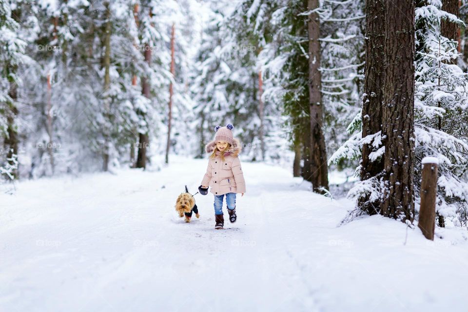 Happy girl in snowy forest 