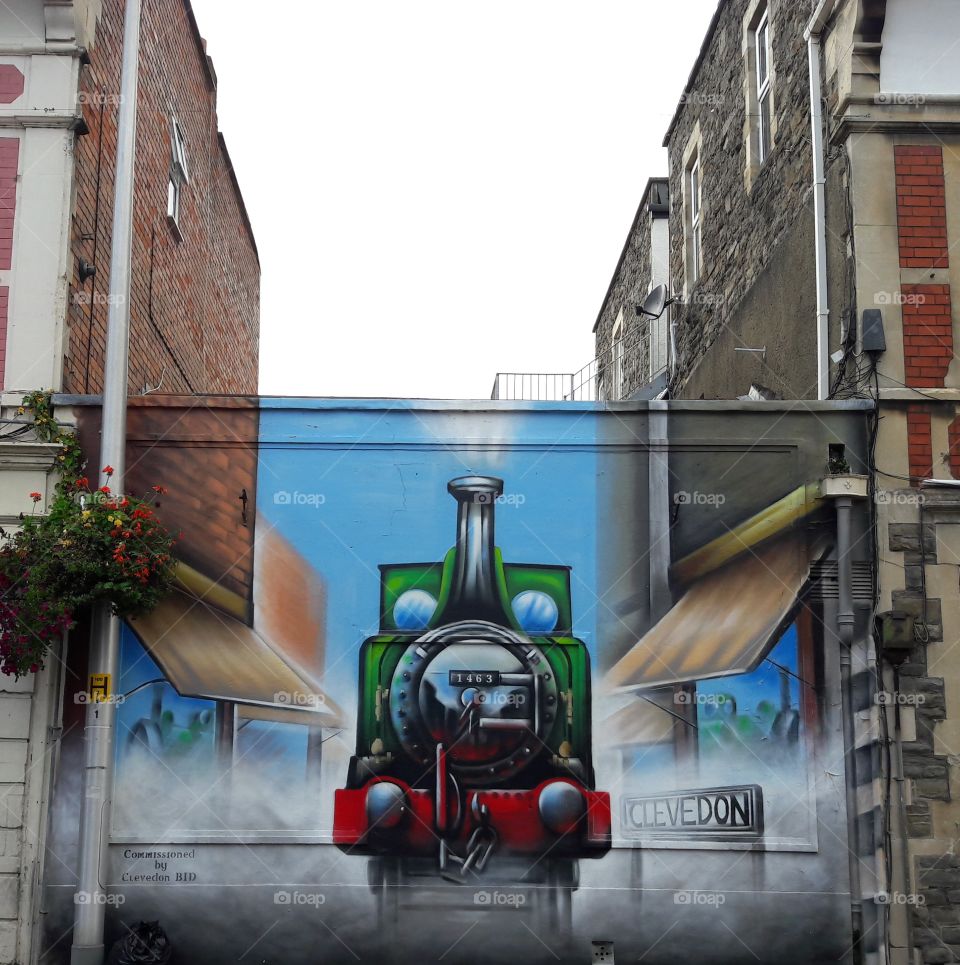 Graffiti art on a shop wall at clevedon somerset with grey sky in between the two buildings