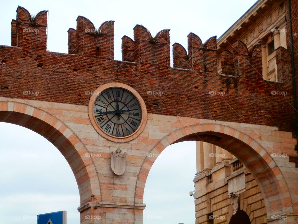 Old entrance walls to the city of Verona, Italy, with the clock