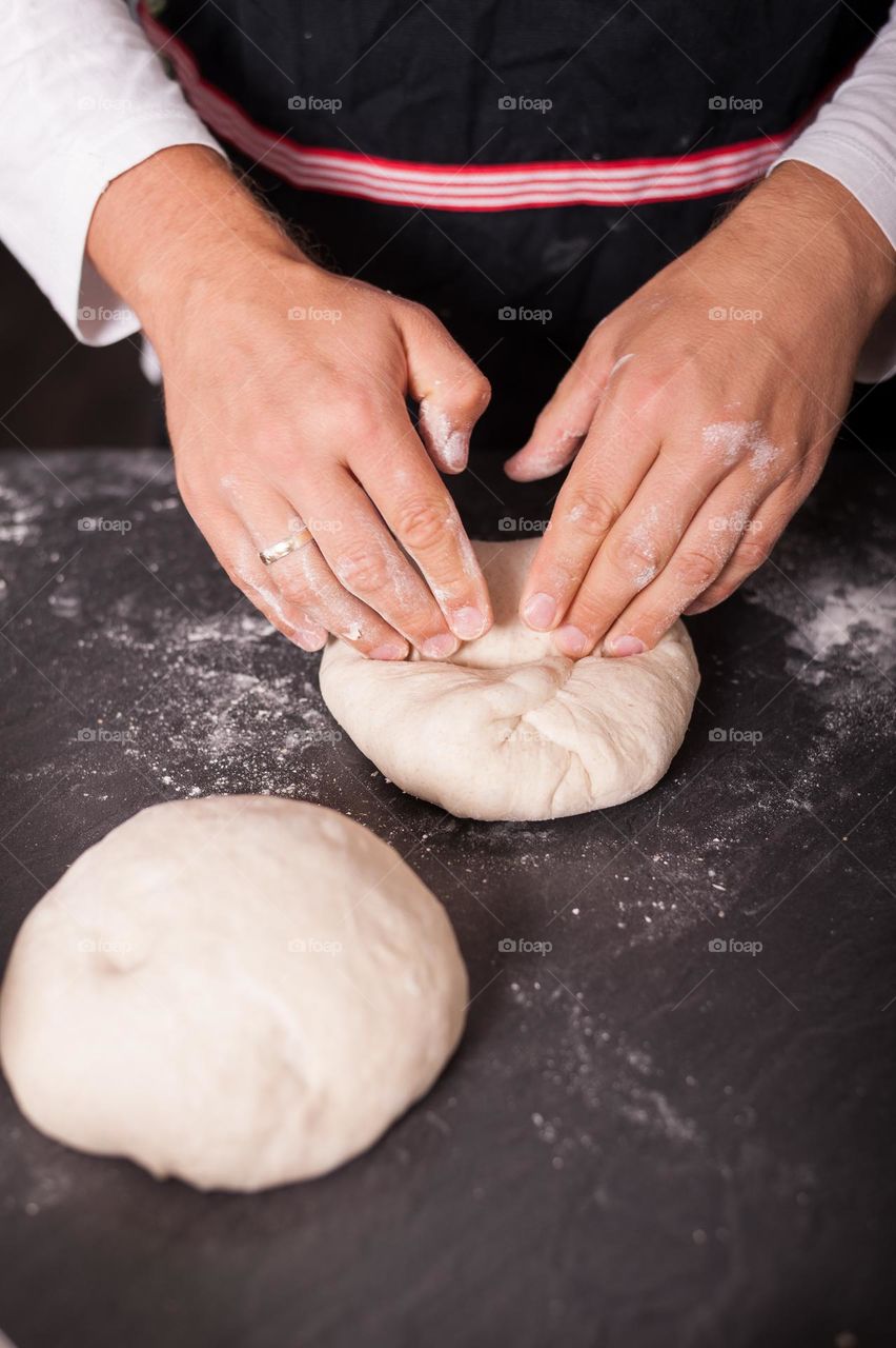 Folding and kneading dough for proofing and release air bubbles. Baking bread at home.