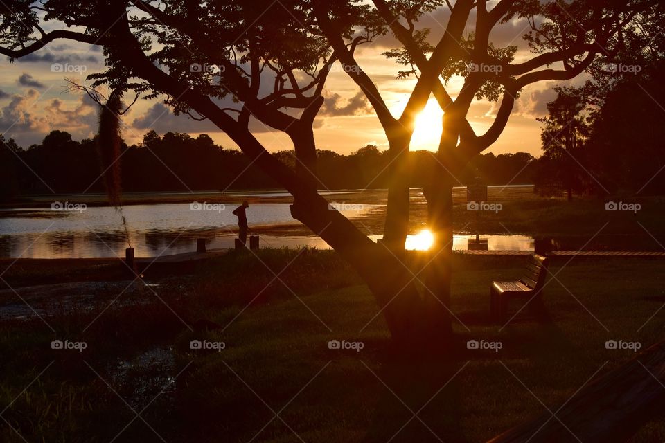 A beautiful sunset descends upon an elderly man in florida after a long days fish and catch.