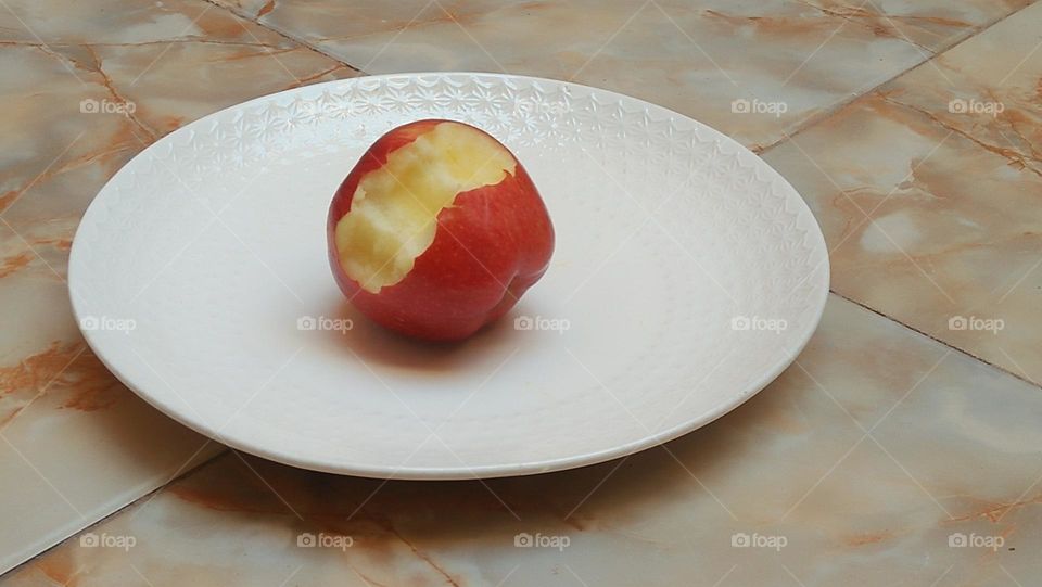 A distilled apple in the middle of a white dish.