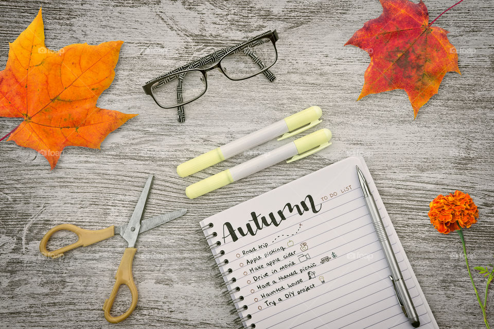 Wooden desktop with a to do list for Autumn on a notebook 