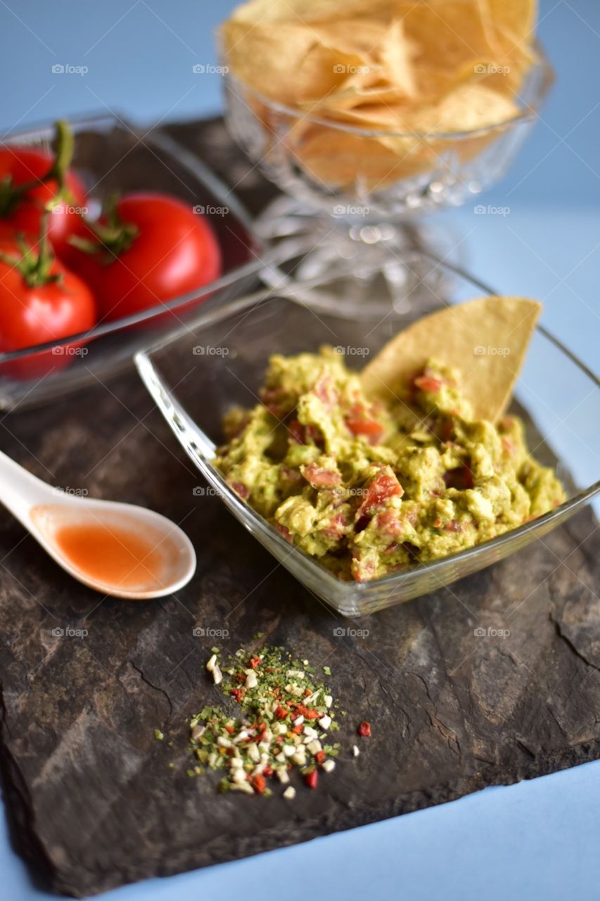 Healthy vegetables for spring time cooking at home. Tomatoes, avocado and spices for the perfect guacamole.