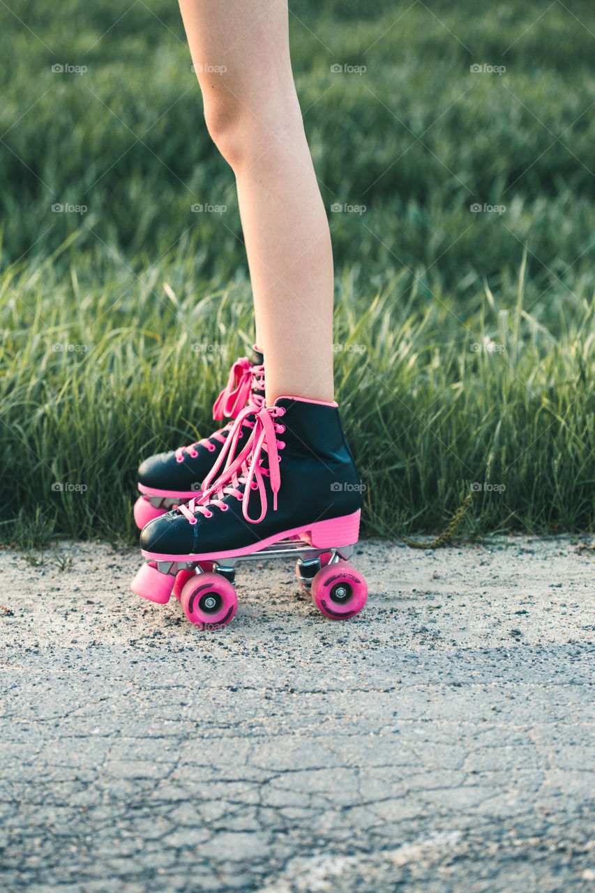 Teenage smiling happy girls having fun rollerskating, jumping, spending time together on summer day. Teenage smiling happy girls having fun walking outdoors, hanging, spending time together on summer day. Real people, authentic situations