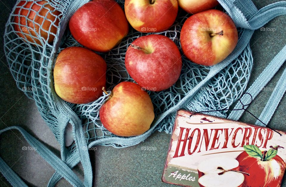 Fruits! - Apples in a light teal-colored string produce bag and vintage metal sign advertising apples