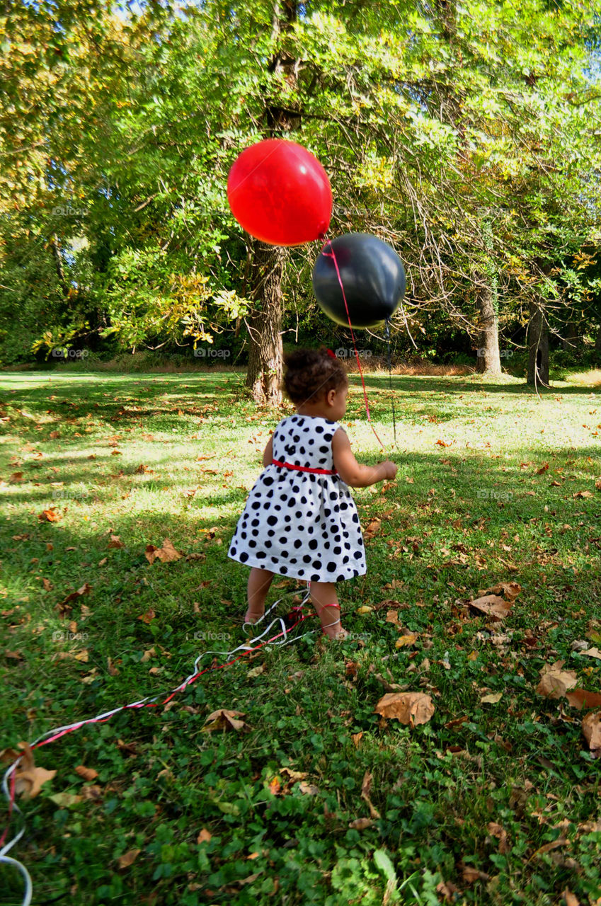 birthday girl. darling one year old with balloons