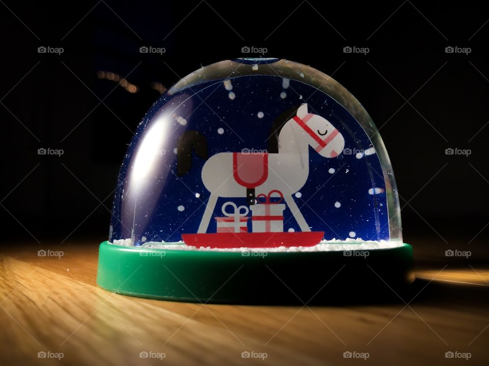 Snow globe with horse in dark background 