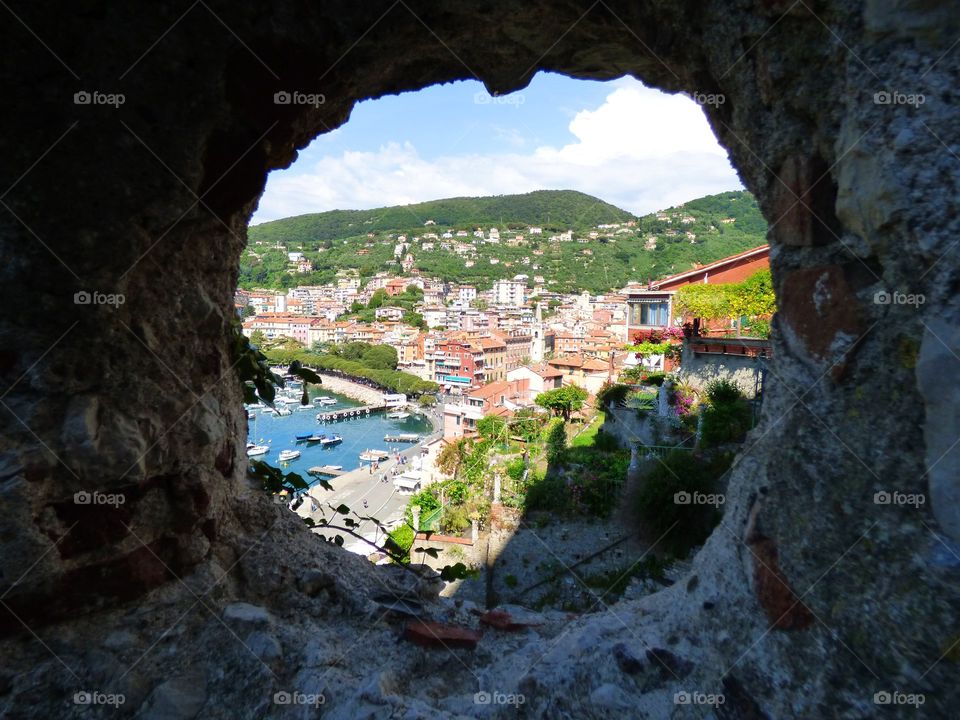 A view from a cannon port of the castle of the seaside town of Lerici Italy on the Mediterranean Sea with boats and buildings
