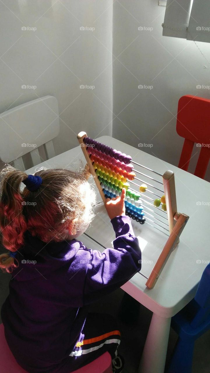 A child plays by Colored pellet setup.