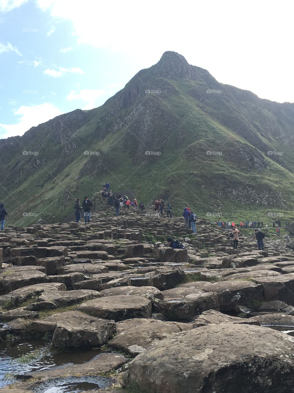 Looking up at a mountain at Giant’s Causeway in Ireland with the rocks at the bottom of the picture 
