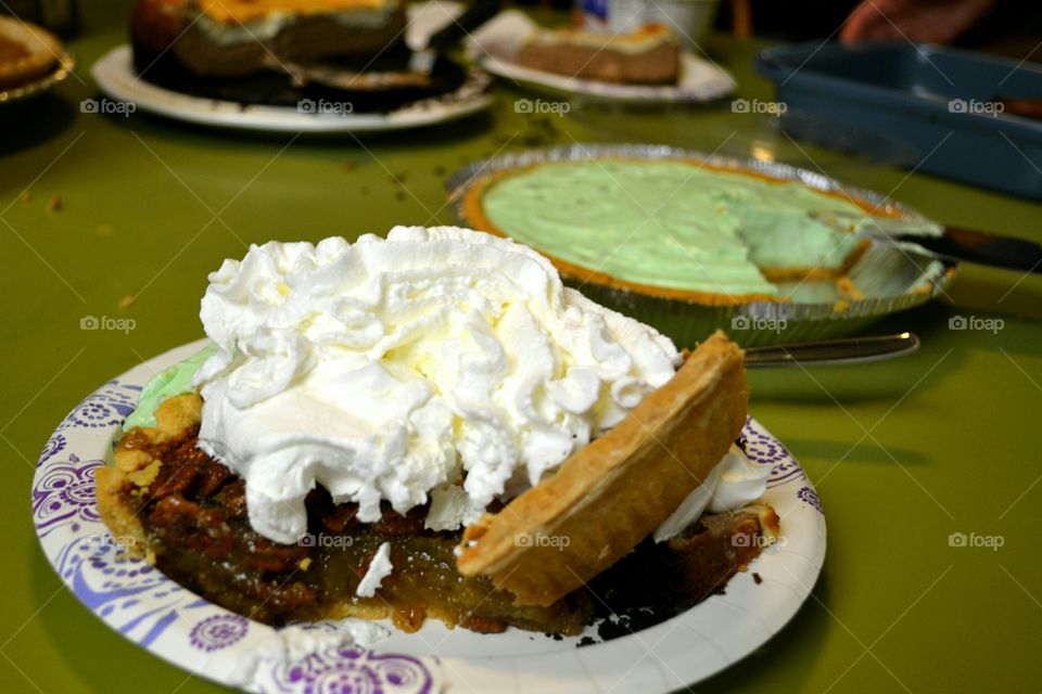 Over the top Thanksgiving indulgence of Pumpkin, Pecan and Pistachio Cream pies with Cheesecake topped with whipped cream all on one plate