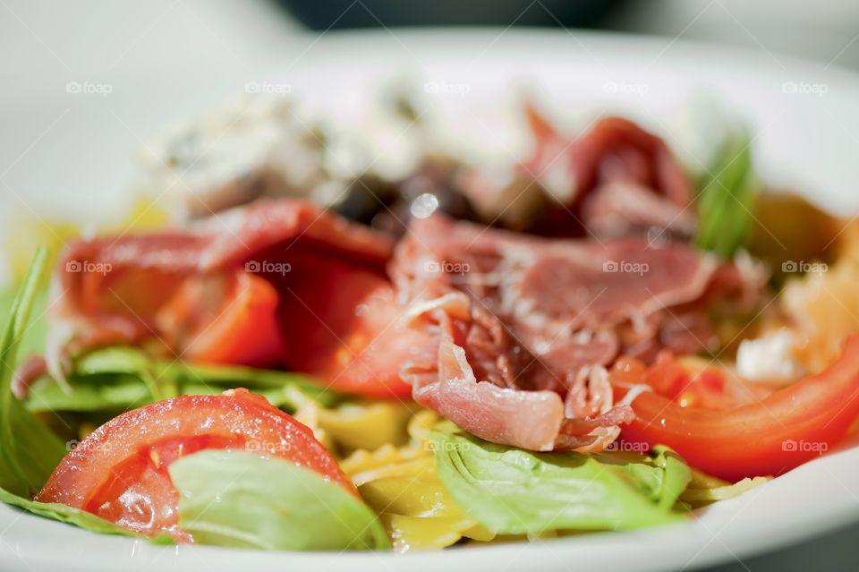 close-up of a young man eating a salad in a light kitchen