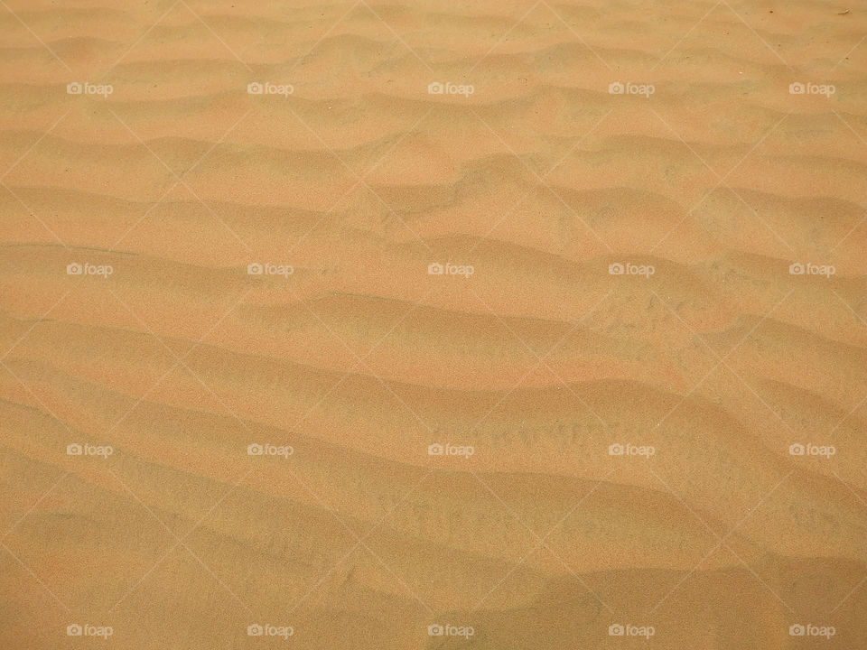 Fine beach sand smooth texture in the summer sun as background