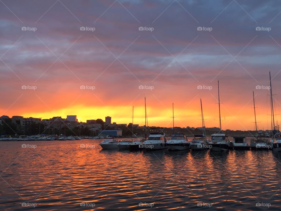 Harbour with boats on the water at sunset
