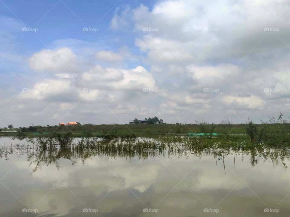 Reflection of clouds, sky, rice fields at Prey Veng Kandal Province Cambodia