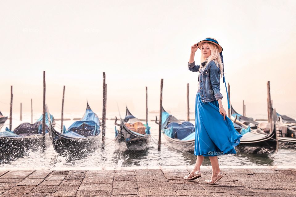 Woman in blue and gondolas in Venice