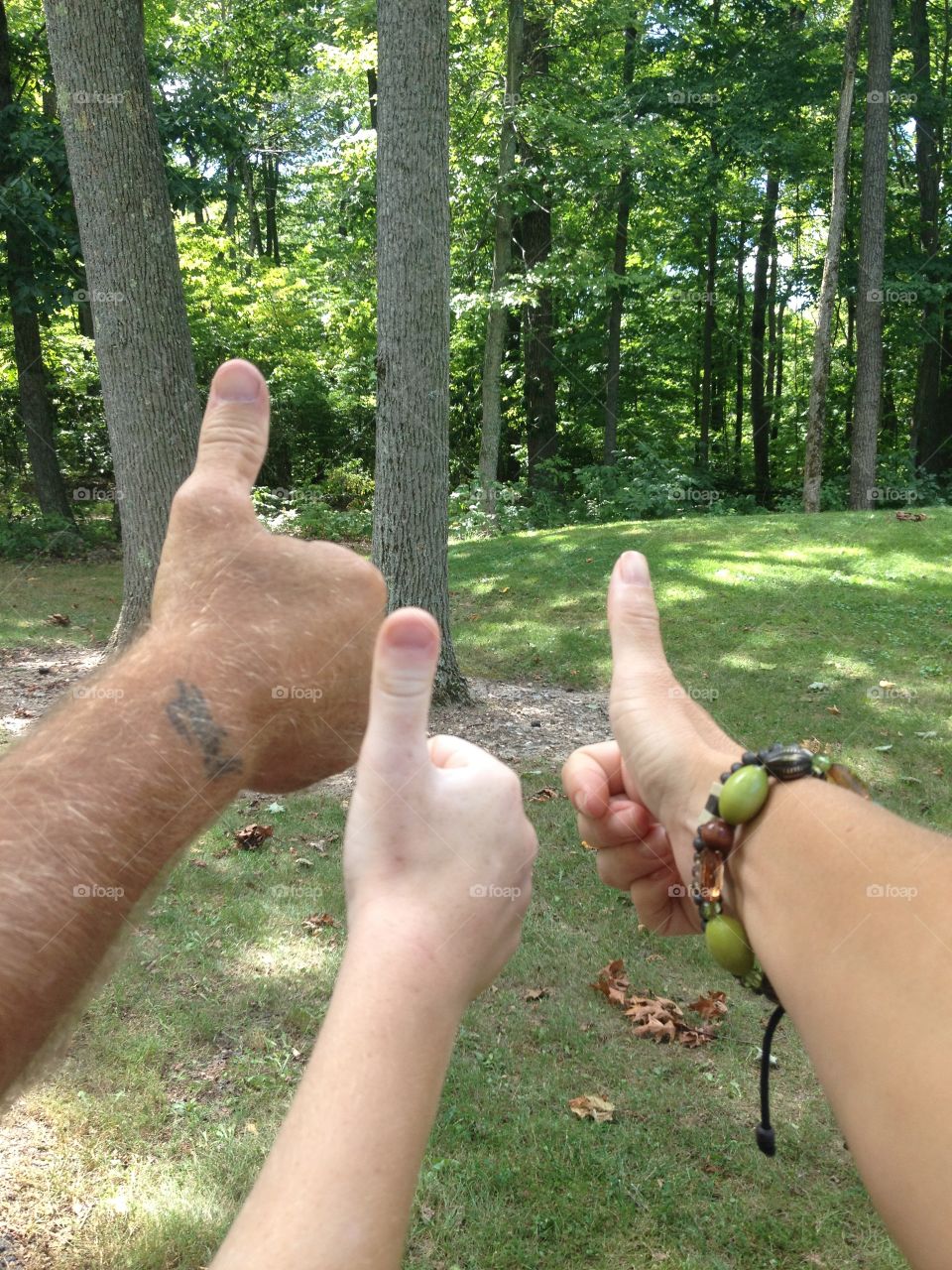 Family of 3 gives thumbs up out in the woods 