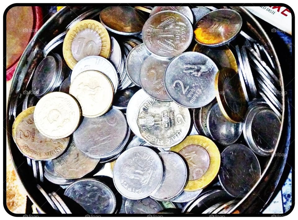 In this photo there is bunch of coins in a bowl.Its shows the currency of india and the coins of ₹1,₹2,₹5 and _10 rupees coins..