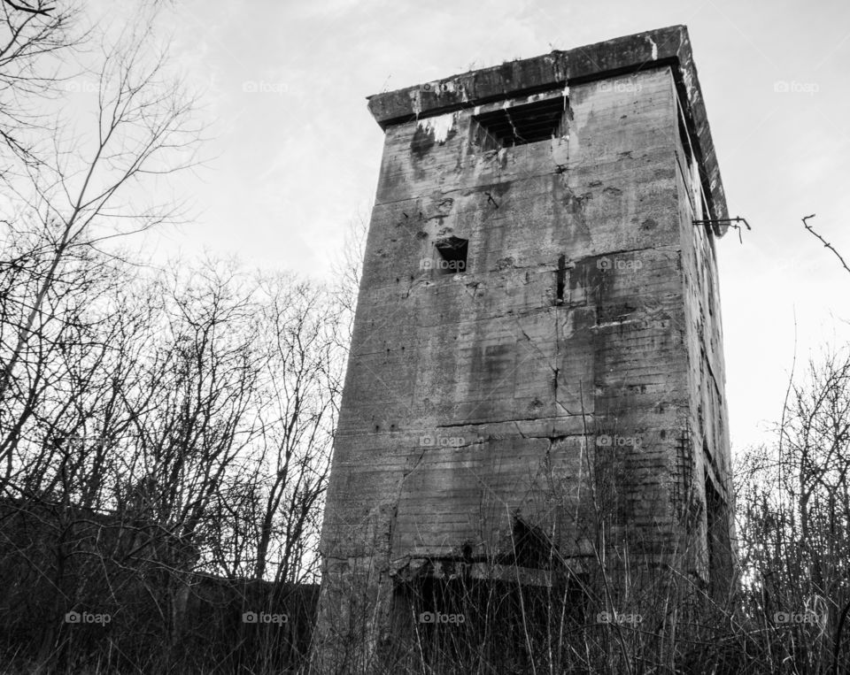 Old concrete WWII guard tower black-white view.