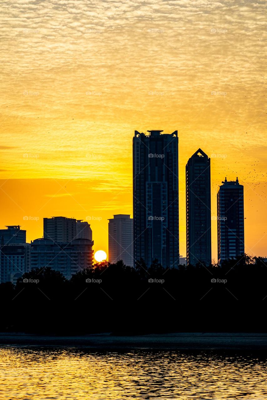 sunset against the backdrop of tall buildings in the emirates