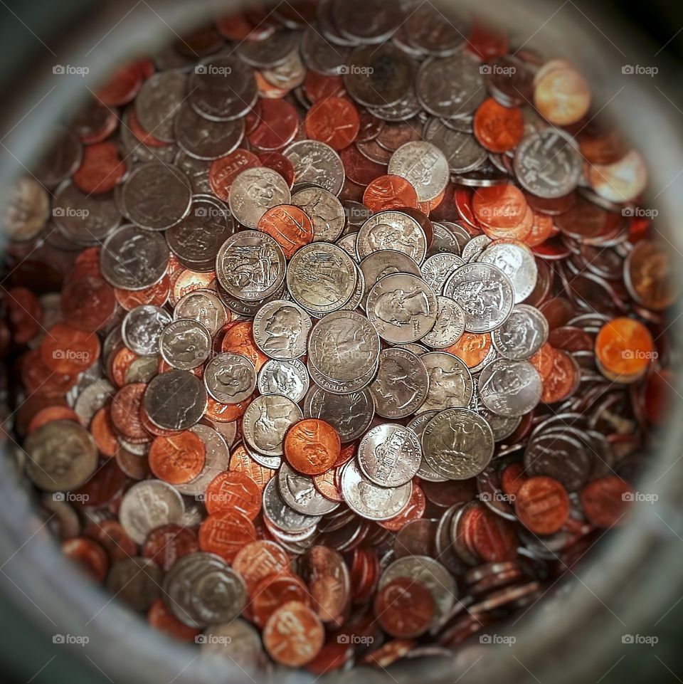 U.S. coins in a large glass carboy looking down from above