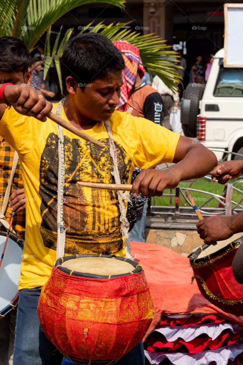 A group of drummer are practicing on the street.