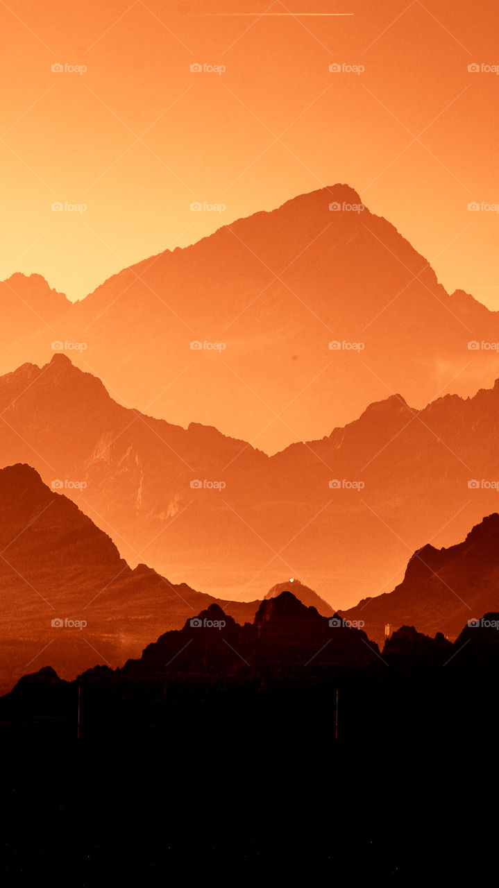 An inspiring red mountain landscape. Tatry mountains in Slovakia. A beautiful wallpaper for smartphone screen. Red abstract gradient with perspective.