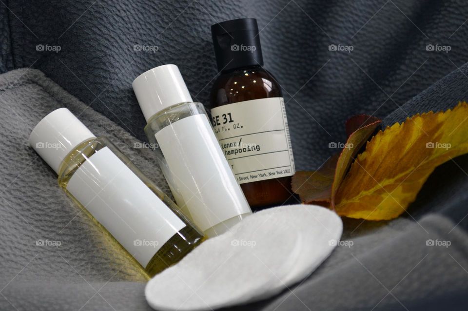 Jars with cream, shampoo and cosmetics on a background with autumn leaves