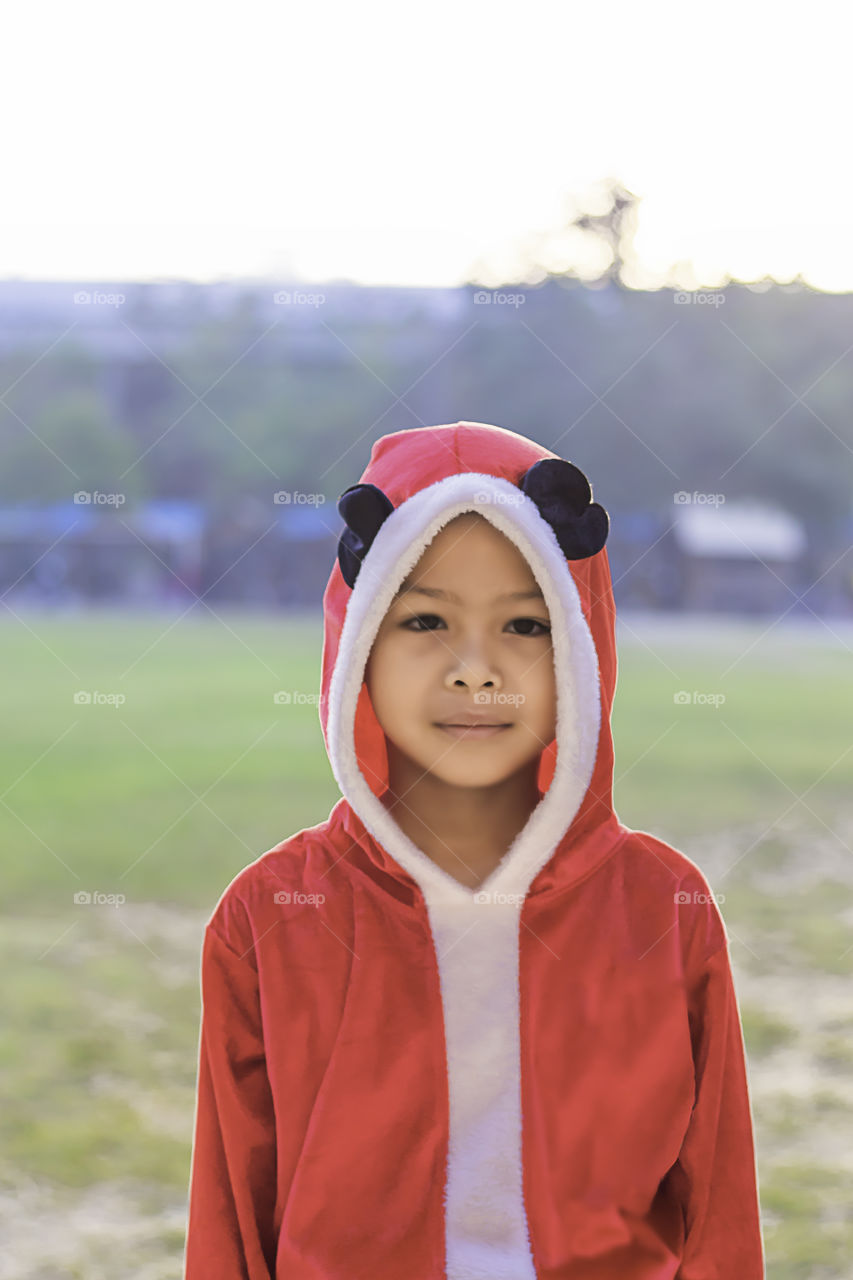 Asia boy wearing a red Christmas Background on the school lawn.