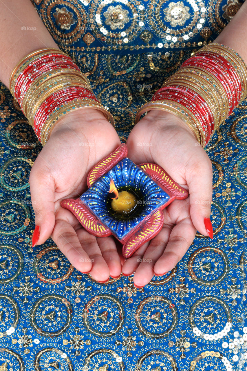 Beautiful Diwali diya oil lamp on a female hand