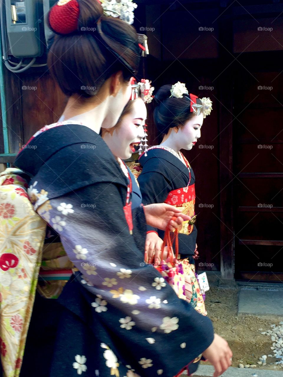 Maikos make their way down the streets of Kyoto 