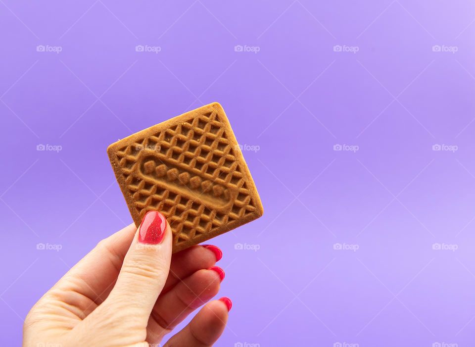 Single square biscuit held by female hand