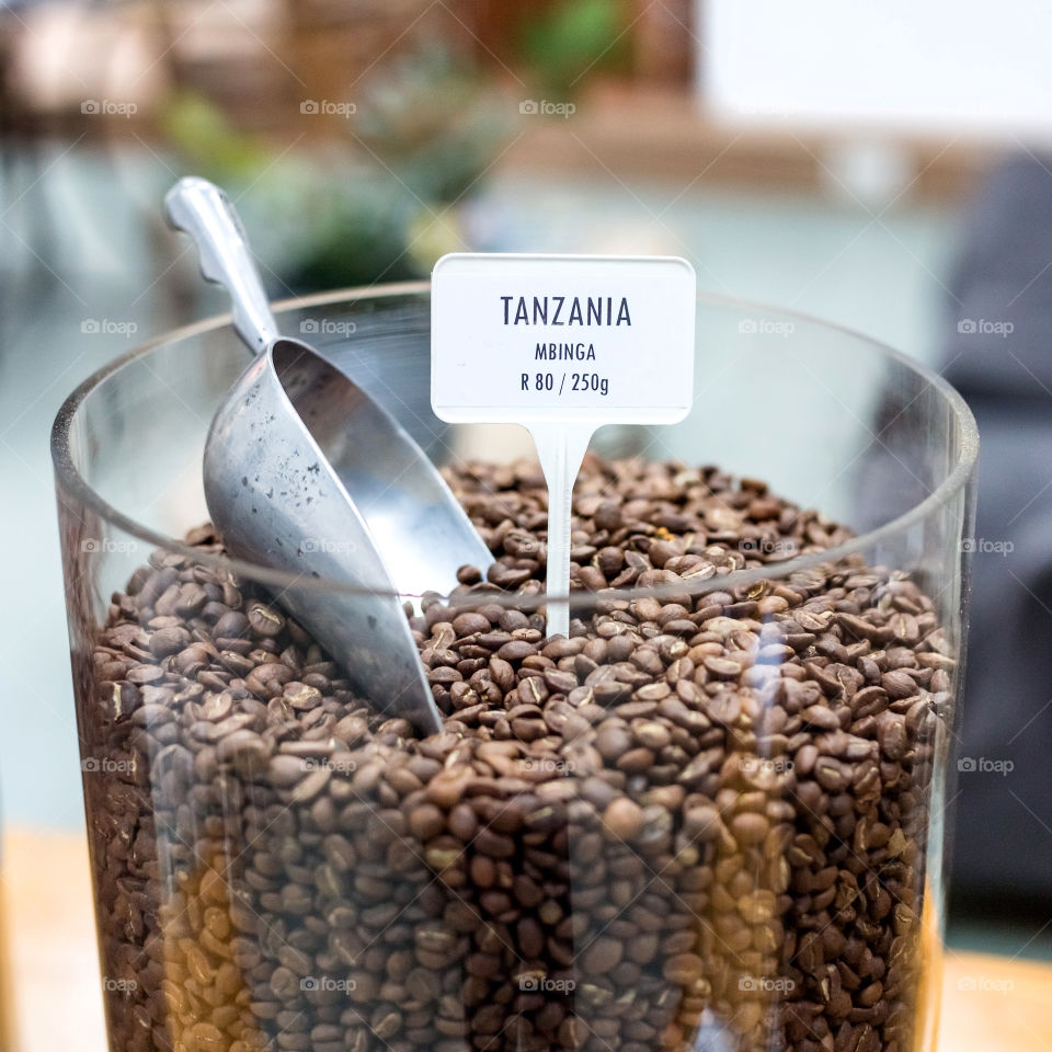 Coffee beans displayed in a large glass jar. 