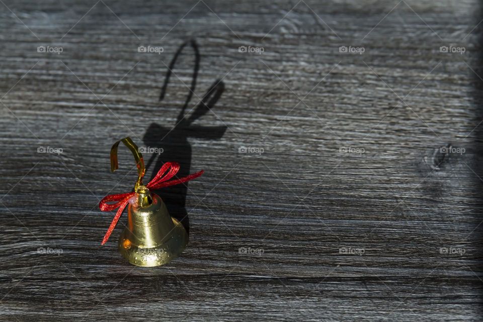 Christmas, golden bell on a wooden surface. Preparation for the new year.