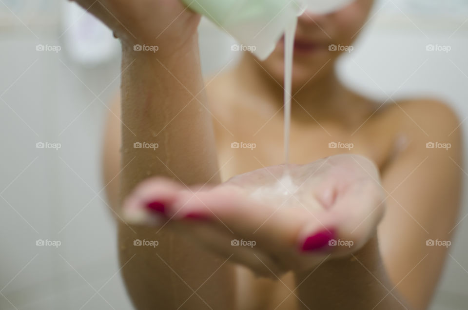 Woman pouring shampoo on her hands