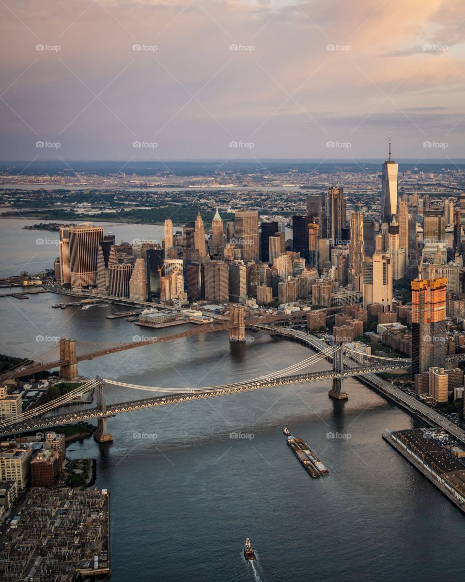 Flying high over NYC during sunrise with both Brooklyn and Manhattan Bridge 