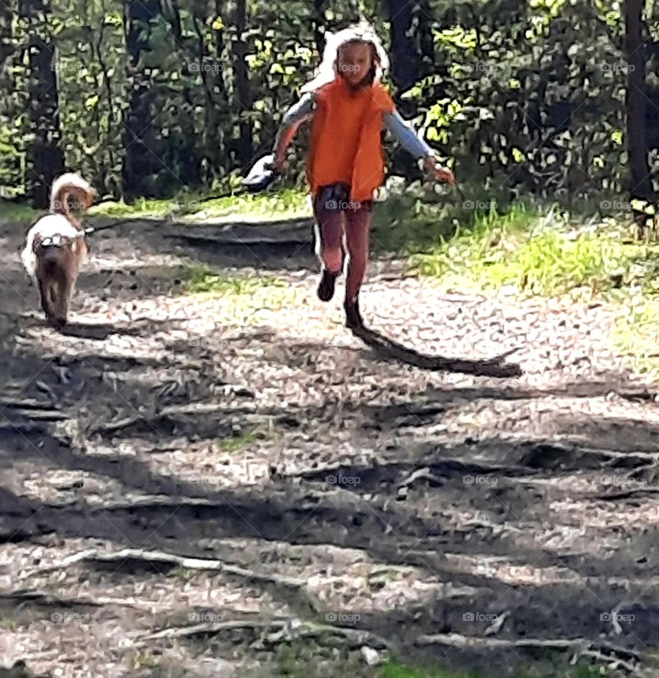 litlle girl running with a dog