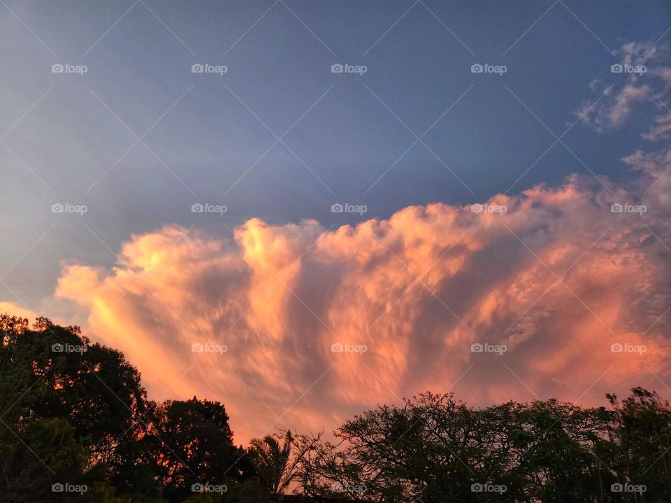Storm clouds building with red coloring of the sun