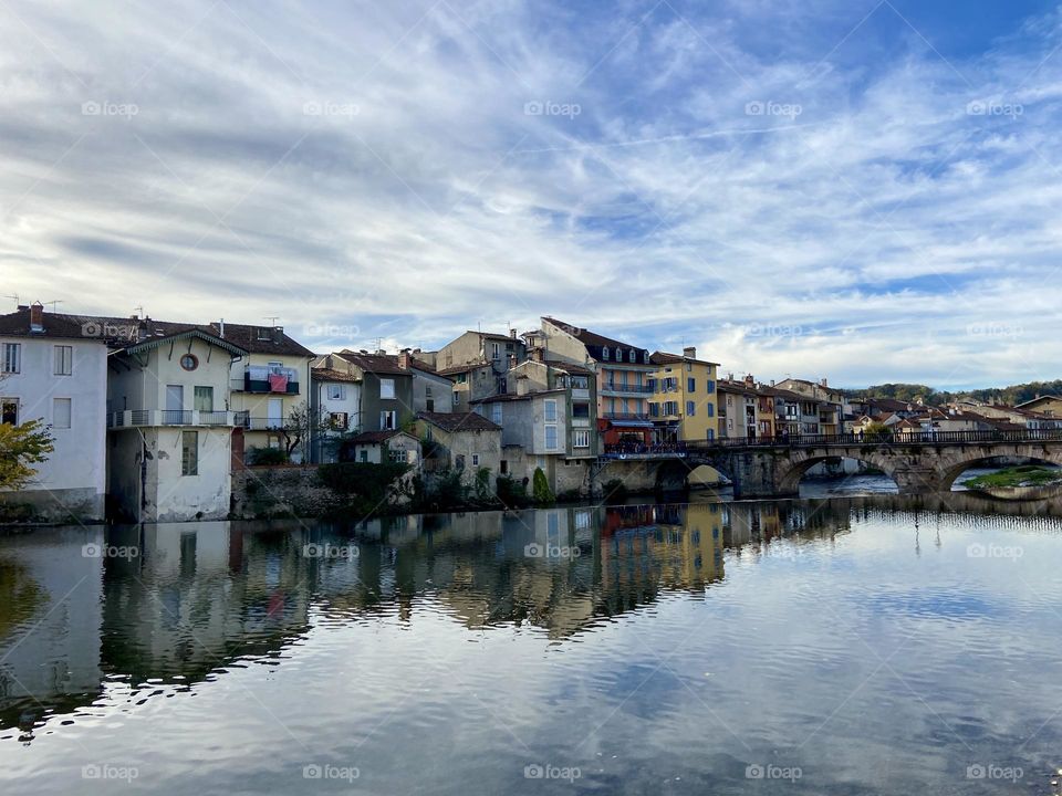 Reflection on the town in the river by cloudy sky