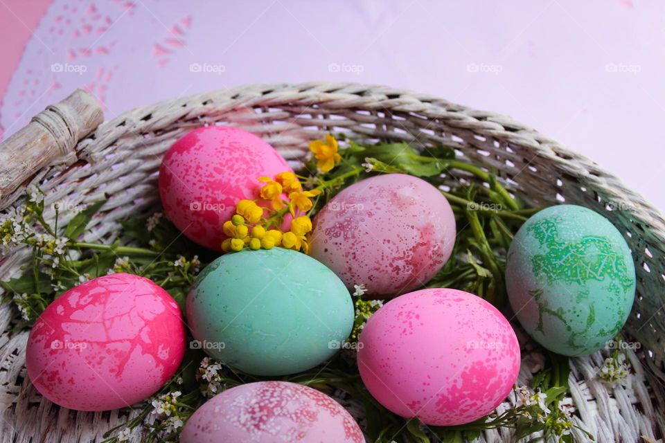 Easter colorful eggs in a white wicker basket.