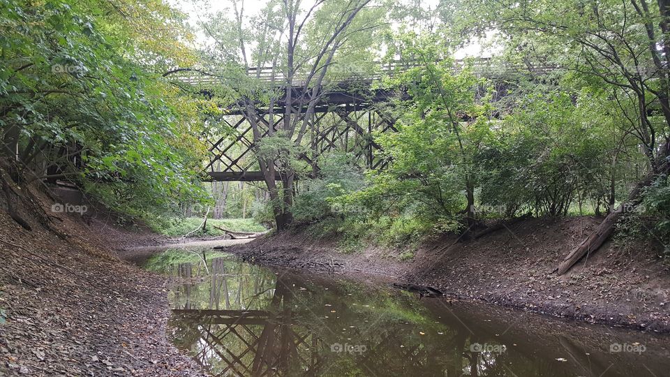 a bridge that supports a bike trail over a stream
