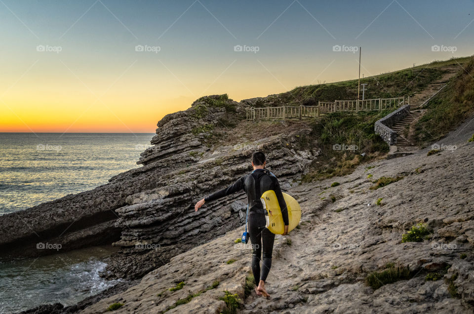 A surfer leaves the beach after Surfing 